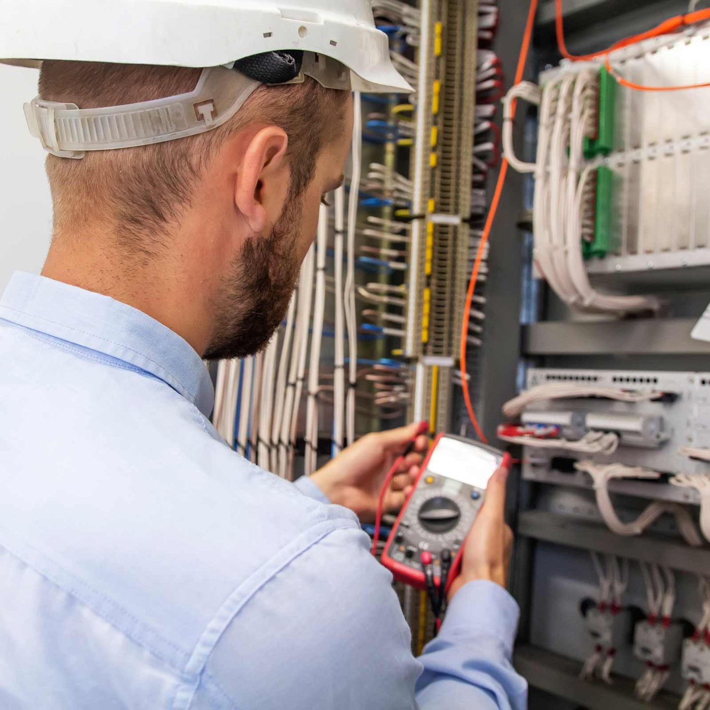 NCCS Group - Electrical Commercial - Engineer testing fusebox with voltmeter.