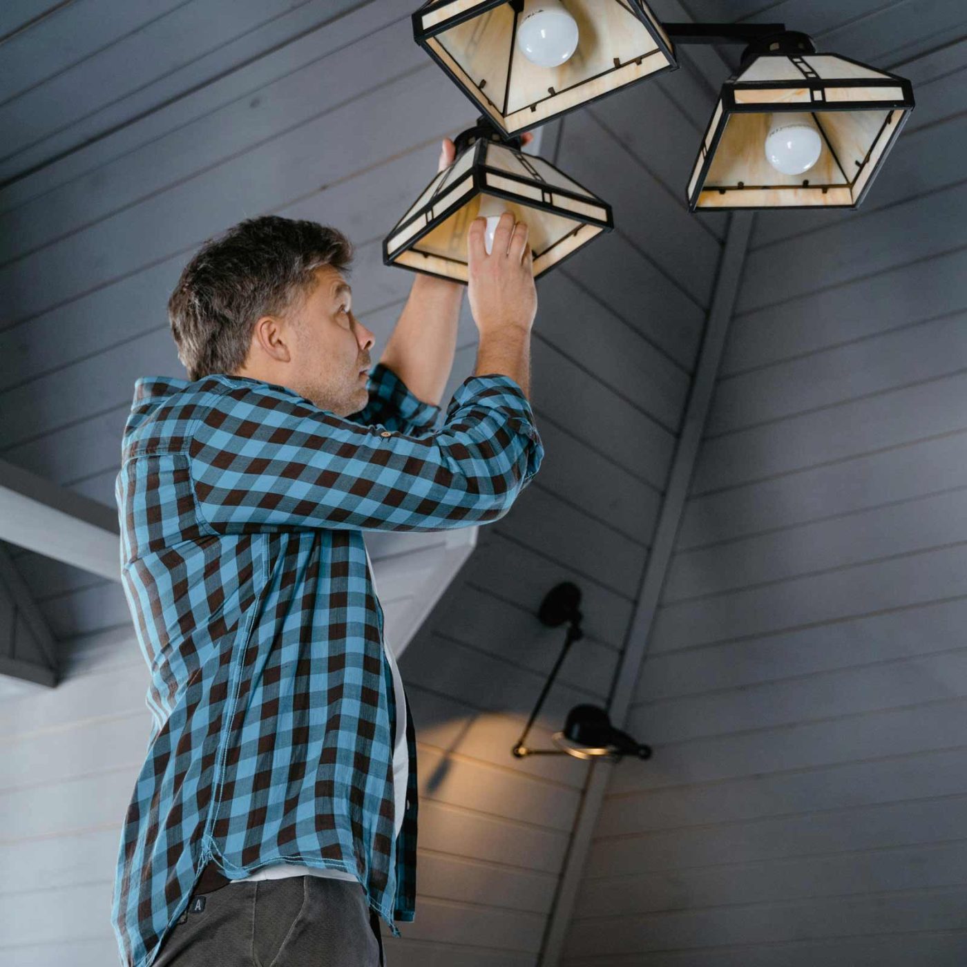 NCCS Group - Electrical Domestic - Man installing ceiling light fixtures.