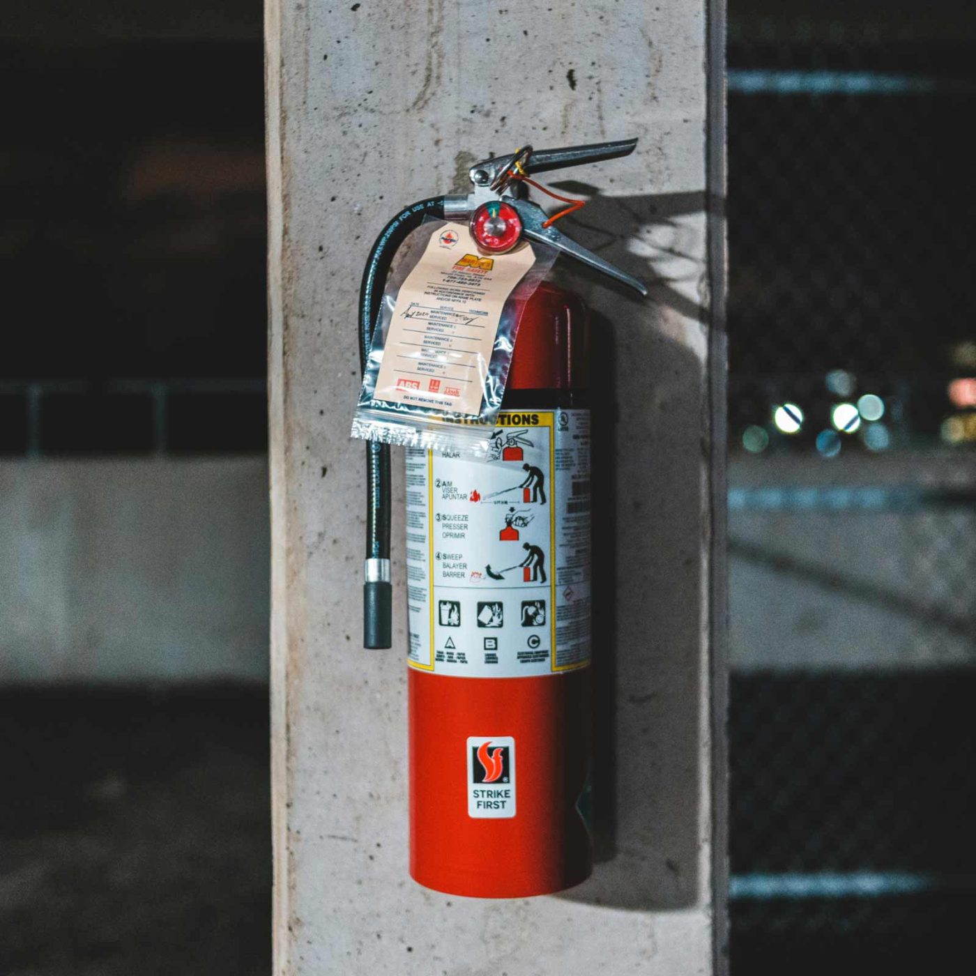 NCCS Group - A fire extinguisher mounted on a cement pillar.