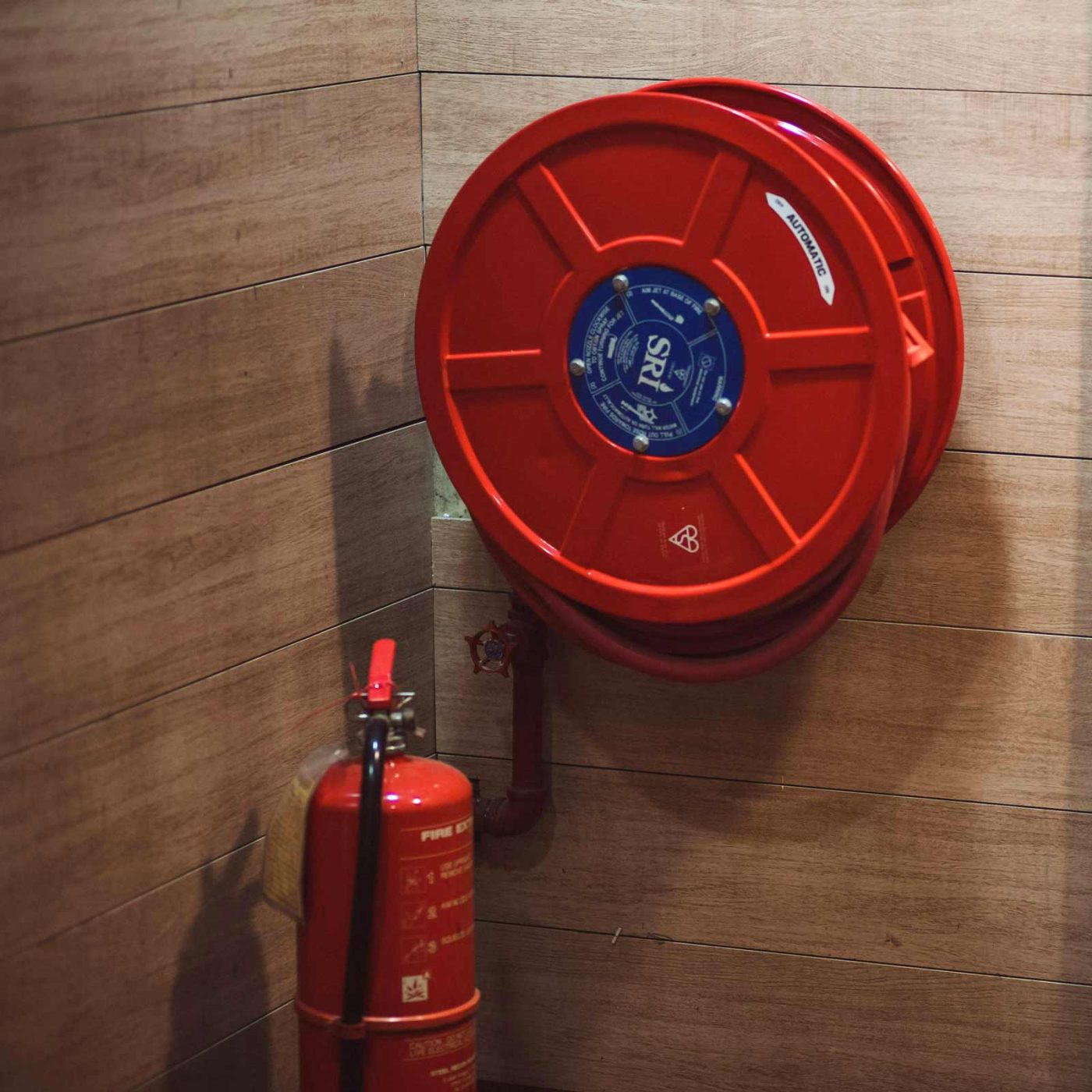 NCCS Group - A fire extinguisher and a fire hose installed on a wall.