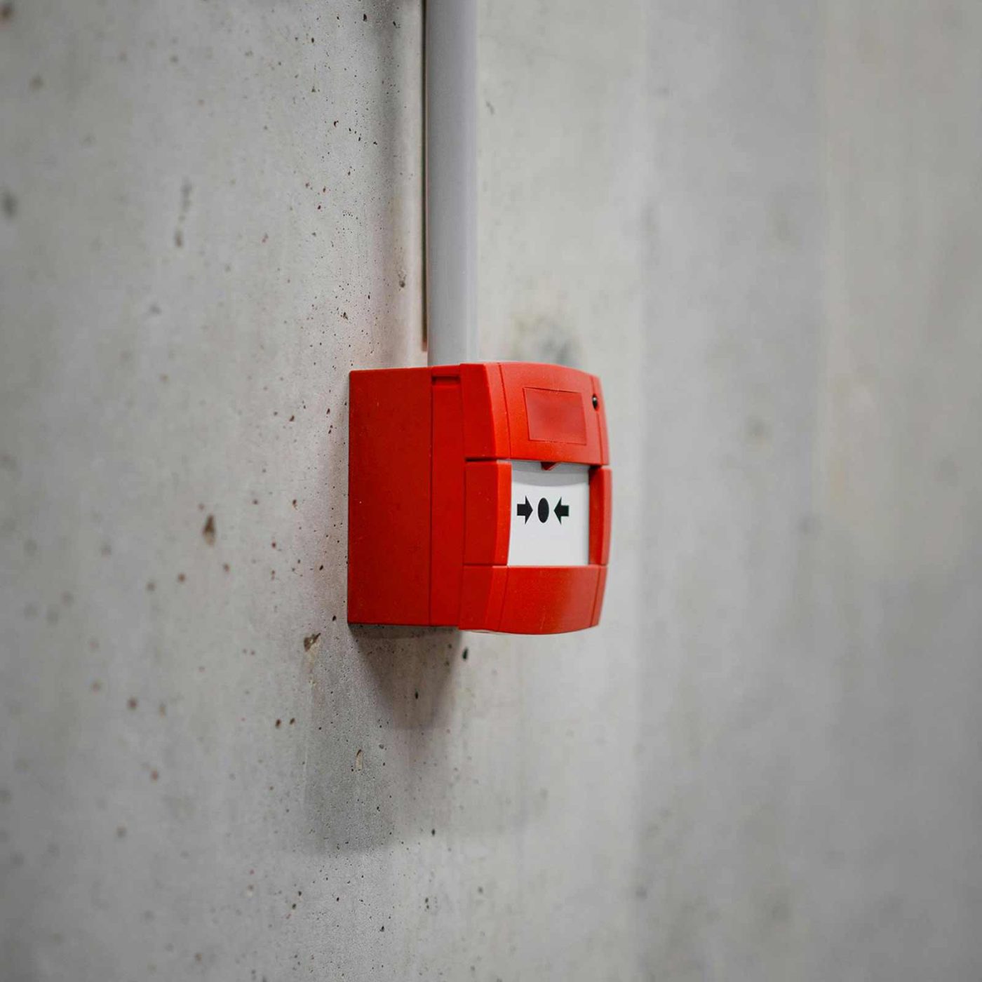 NCCS Group - Fire Safety Services - Fire alarm installed on a cement wall.