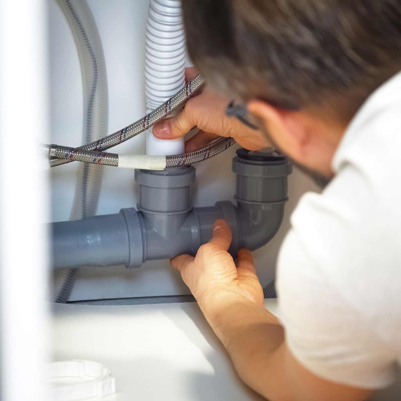 NCCS Group - A heating engineer fitting a pipe into bracket, maintenance.