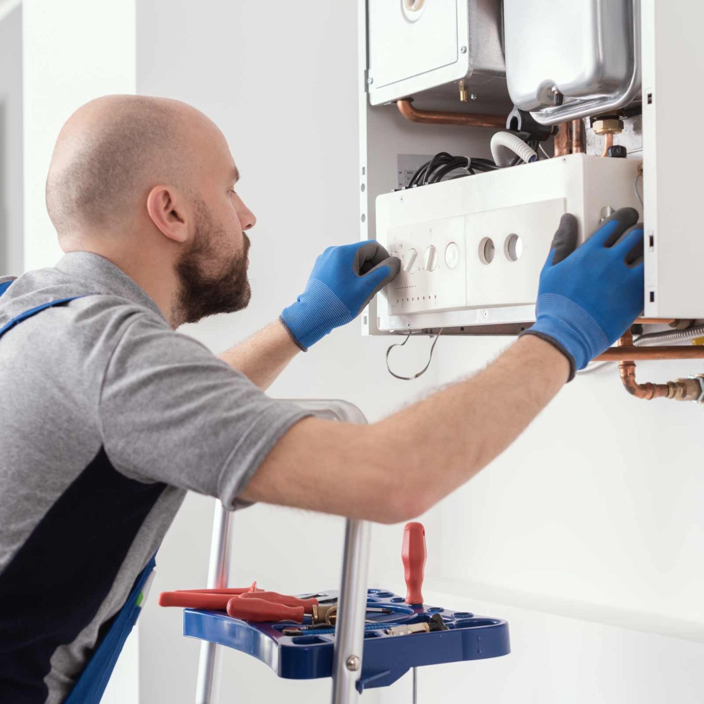 NCCS Group - A heating engineer installing a panel on a boiler.