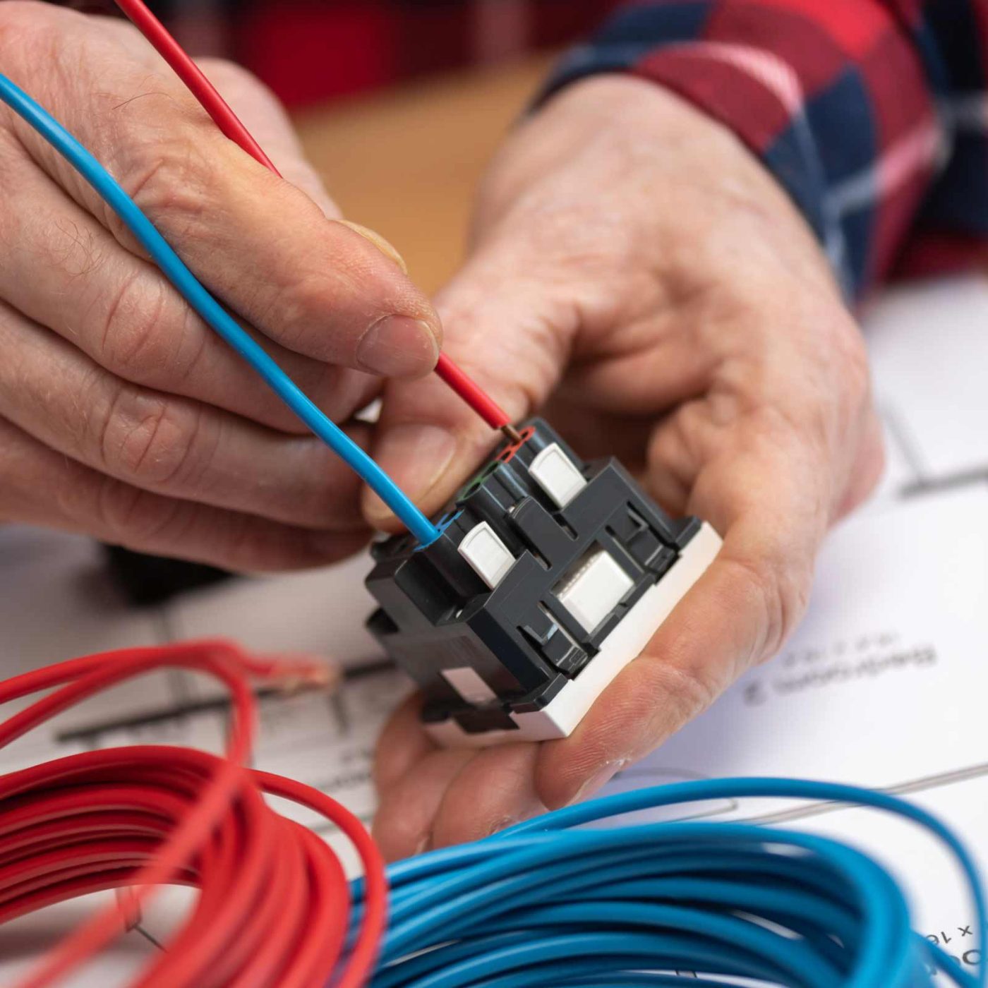 NCCS Group - An electrical engineer wiring up wires to a plug adapter.